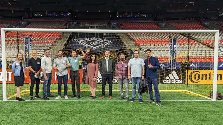Group of people standing in front of a soccer net