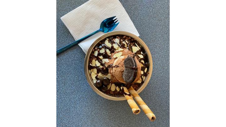 Shaved ice cream dessert covered in chocolate.