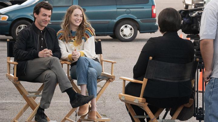 Man and woman smiling while being interviewed.