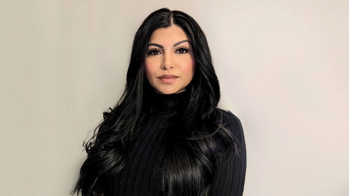 Woman with long black hair wearing a black turtleneck top.