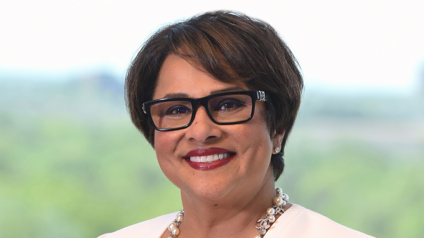 Woman wearing glasses and smiling.