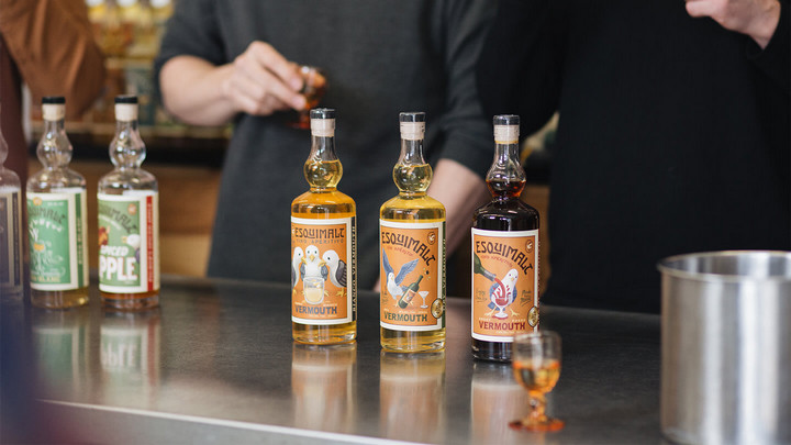 Bottles of Esquimalt Vermouth on a stainless steal countertop.