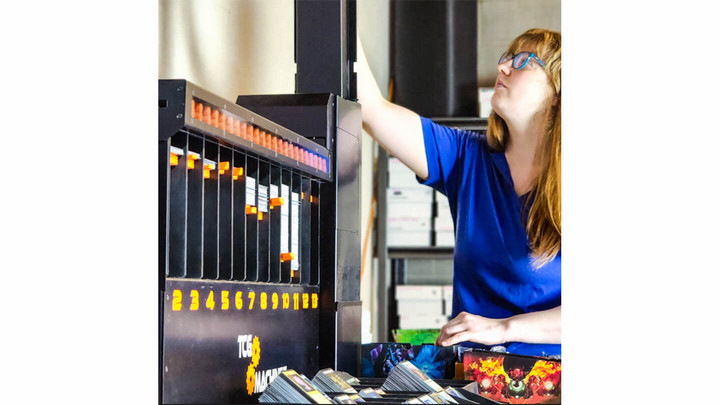 A person inserting trading cards into a sorting machine.