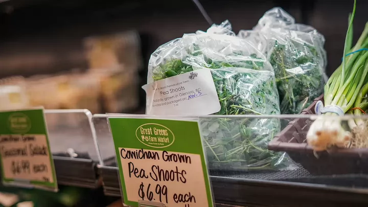 A bag of pea shoots on a grocery store shelf. 