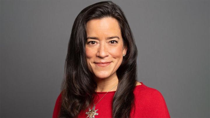 Woman in red sweater smiling.