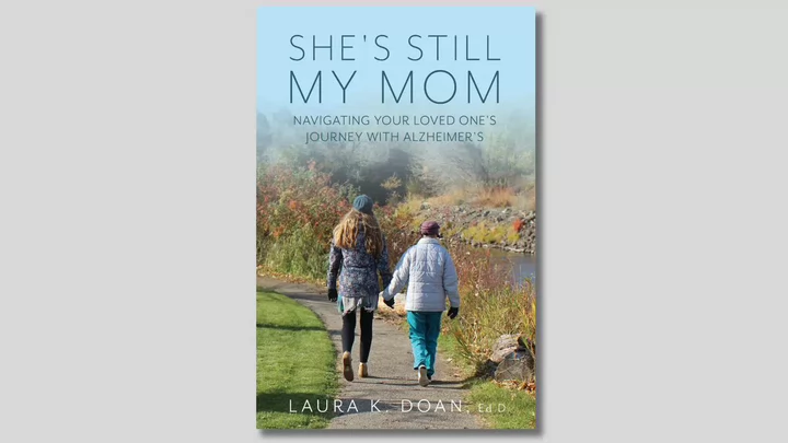 Cover of a book titled She's Still My Mom: Navigating Your Loved One's Journey with Alzheimer's by Laura K Doan.