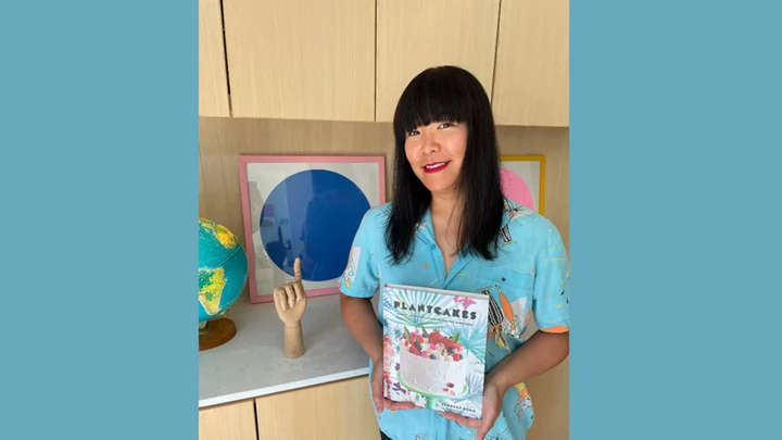 Woman holding a book titled Plantcakes.
