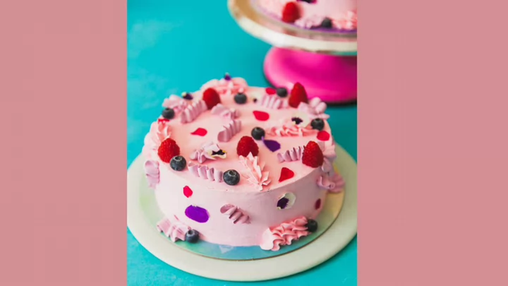 A cake decorated with raspberries on top.
