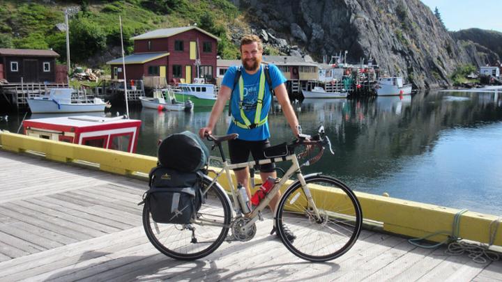 Man with a bike in front of a harbour