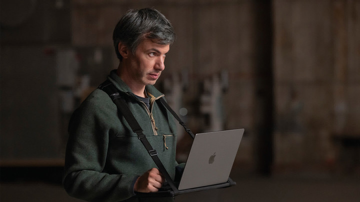 A man with a laptop computer affixed to his body with shoulder straps.