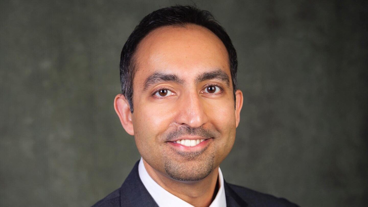 Man in suit and tie smiling. 