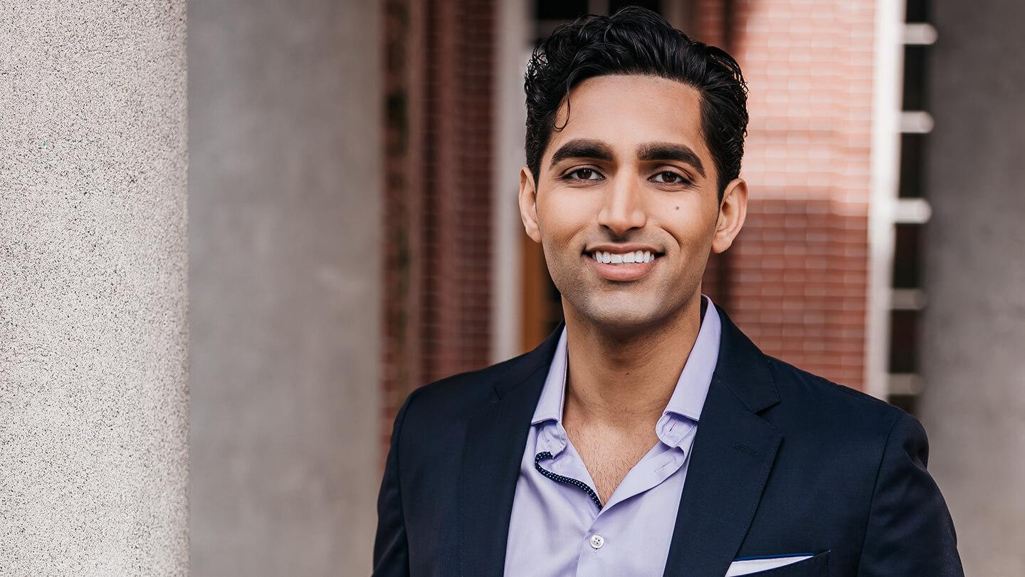 Man smiling and wearing a jacket, dress shirt and no tie. 