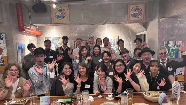 A group of people in a Japanese bar posing for a photo.