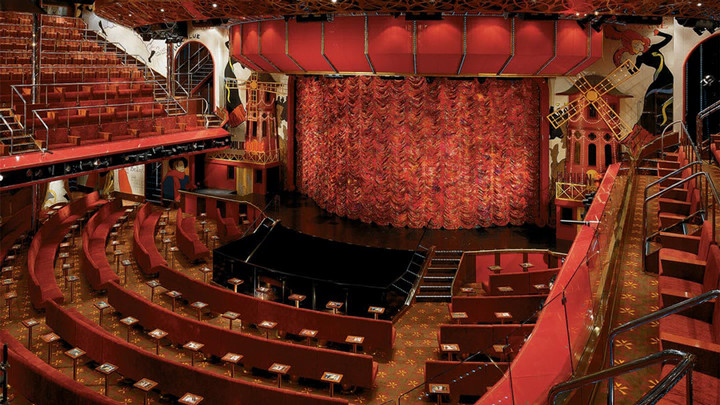 An empty theatre with curtains closing off the rounded stage.