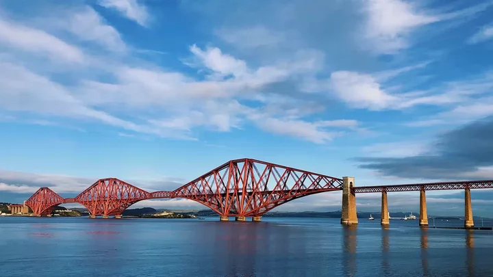 A red metal bridge spanning a river. 