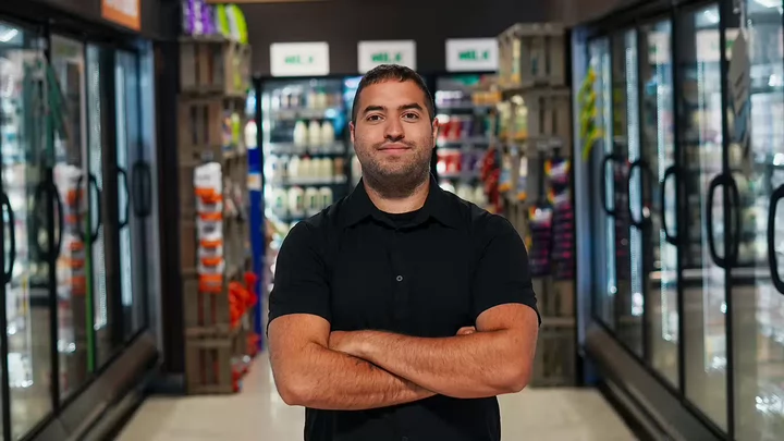 Yashar Samin standing with his arms cross in the frozen foods aisle of a grocery store. 