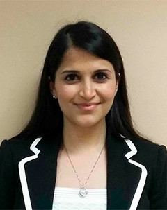 Women with dark hair and jacket smiling.