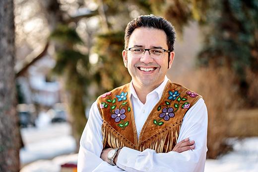 Man smiling while standing outdoors.