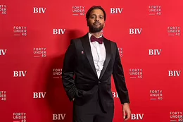 A bearded man in a tuxedo standing in front of a backdrop that says BIV Forty Under 40 Awards