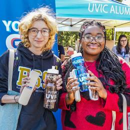 Two students outside at Thunderfest event holding water bottles.