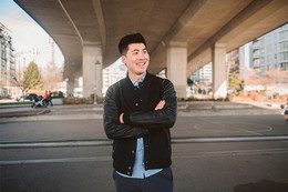 Man standing crossed armed under a viaduct.
