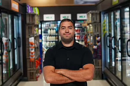 Founder of the Baski shopping app Yashar Samin stands in the frozen food section of a grocery story.