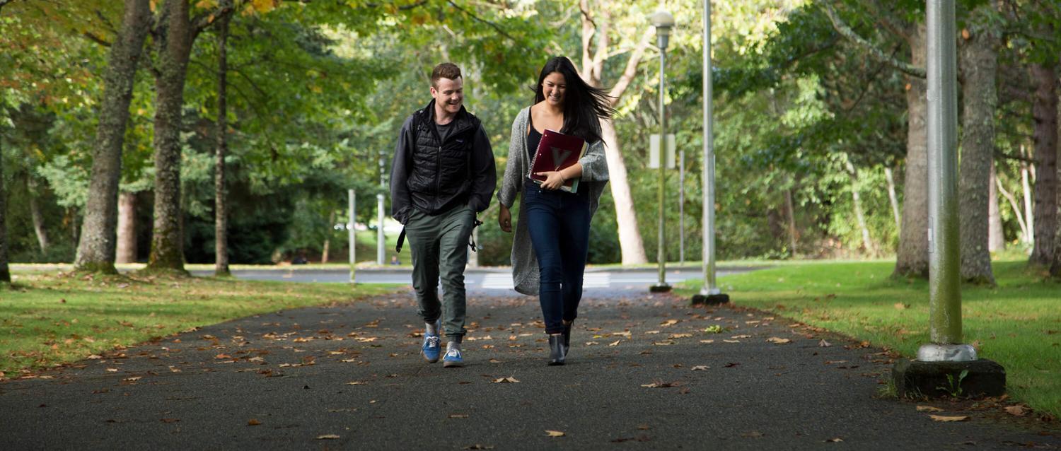 Two students walking across campus