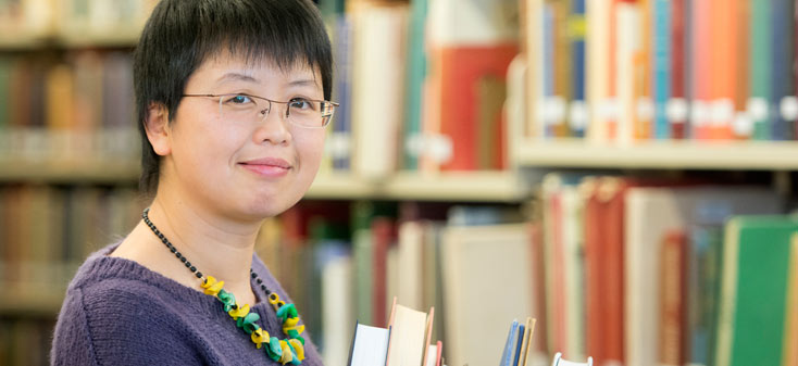 A UVic librarian holding books