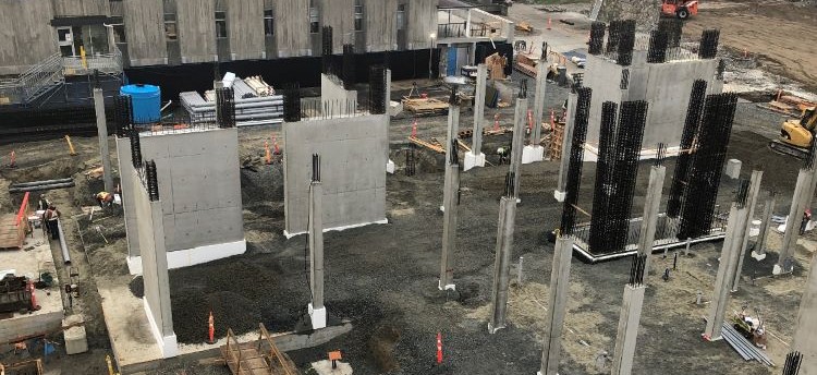 Construction site as seen from a birds-eye-view showing many vertical concrete structures in the site.