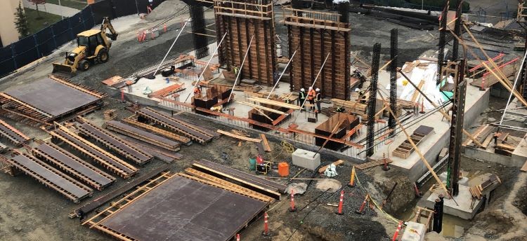 Construction site depicting vertical elements being constructed on top of a concrete foundation.