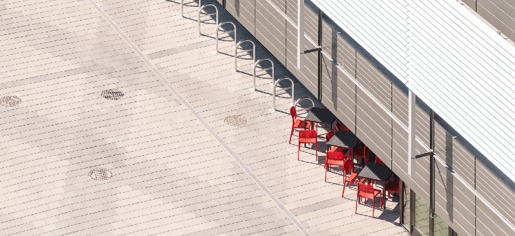 Bike racks for storage along the side of Building 1 next to orange seating