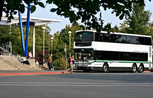 A BC Transit bus parked outside of the UVic Bookstore in the Transit exchange