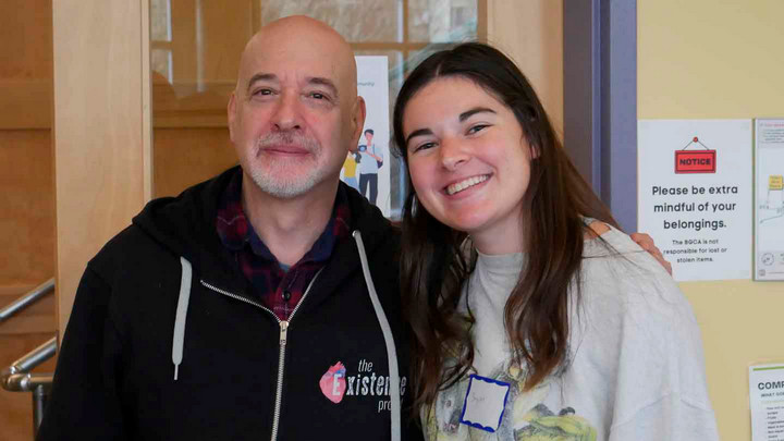 Two people wearing name tags smile at the camera.