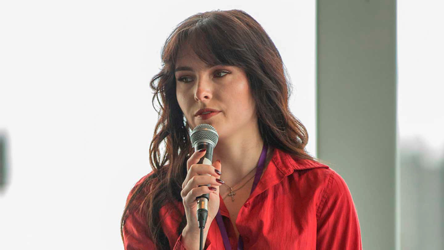 A photo of a student speaking into a microphone.
