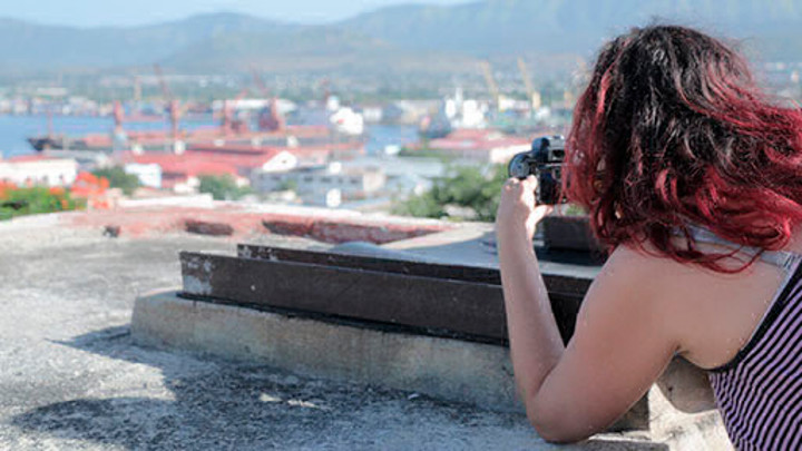 A student taking a photo from a rooftop in Cuba.