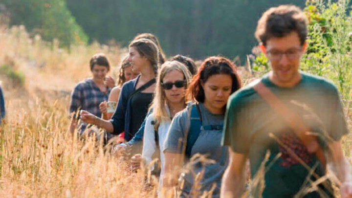 A group of students walk through a field.