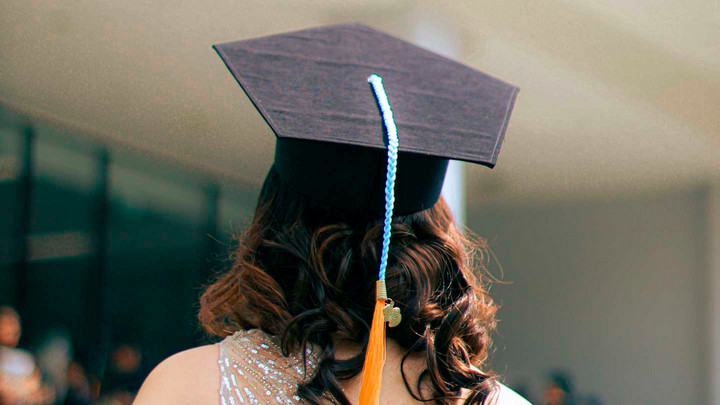 A photo of a person wearing a graduation cap facing away from the camera.