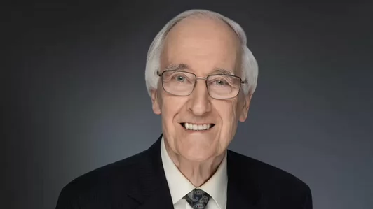Photo of smiling older man with white hair and glasses