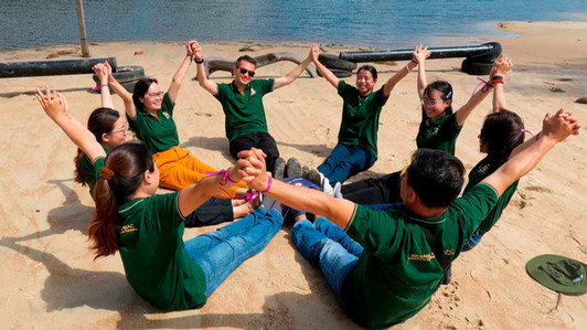 People sit on a bit with their legs together in a circle.
