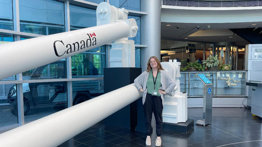 A students stands in front of a large mechanical device