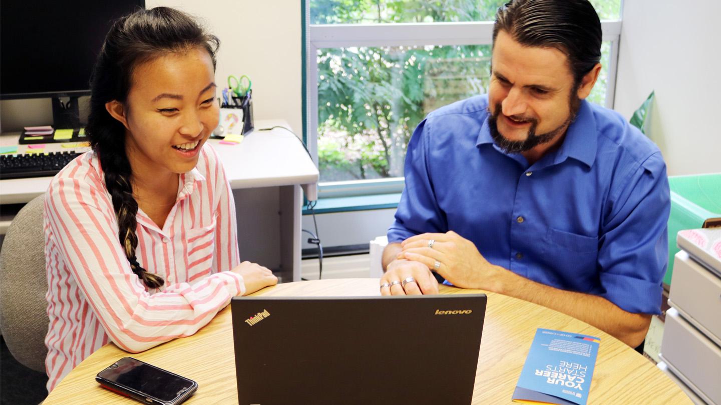 career educator with student at laptop