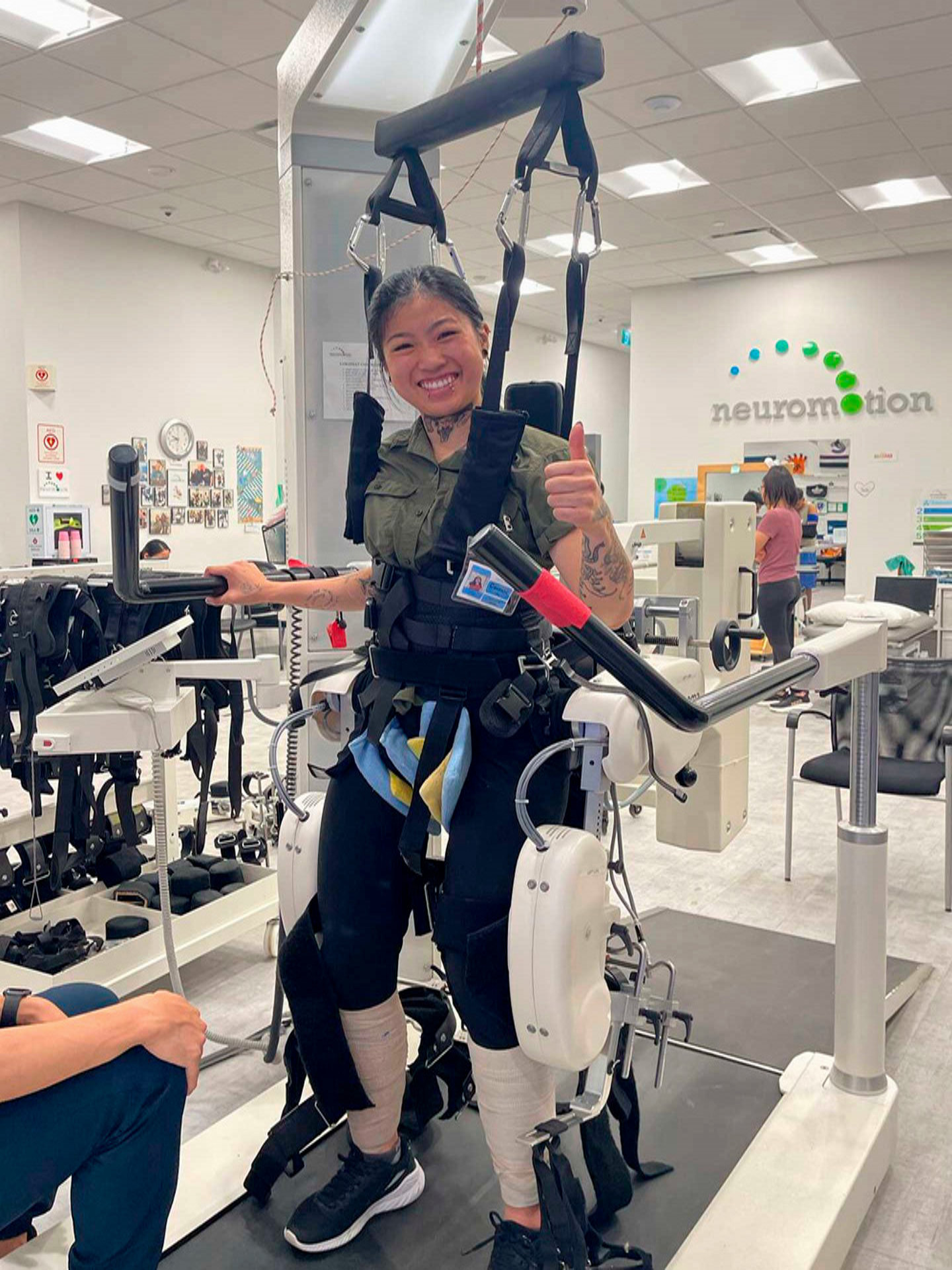 A student demonstrates how to use a machine in a kinesiology office.