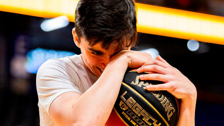 A student holding a basketball on the court.