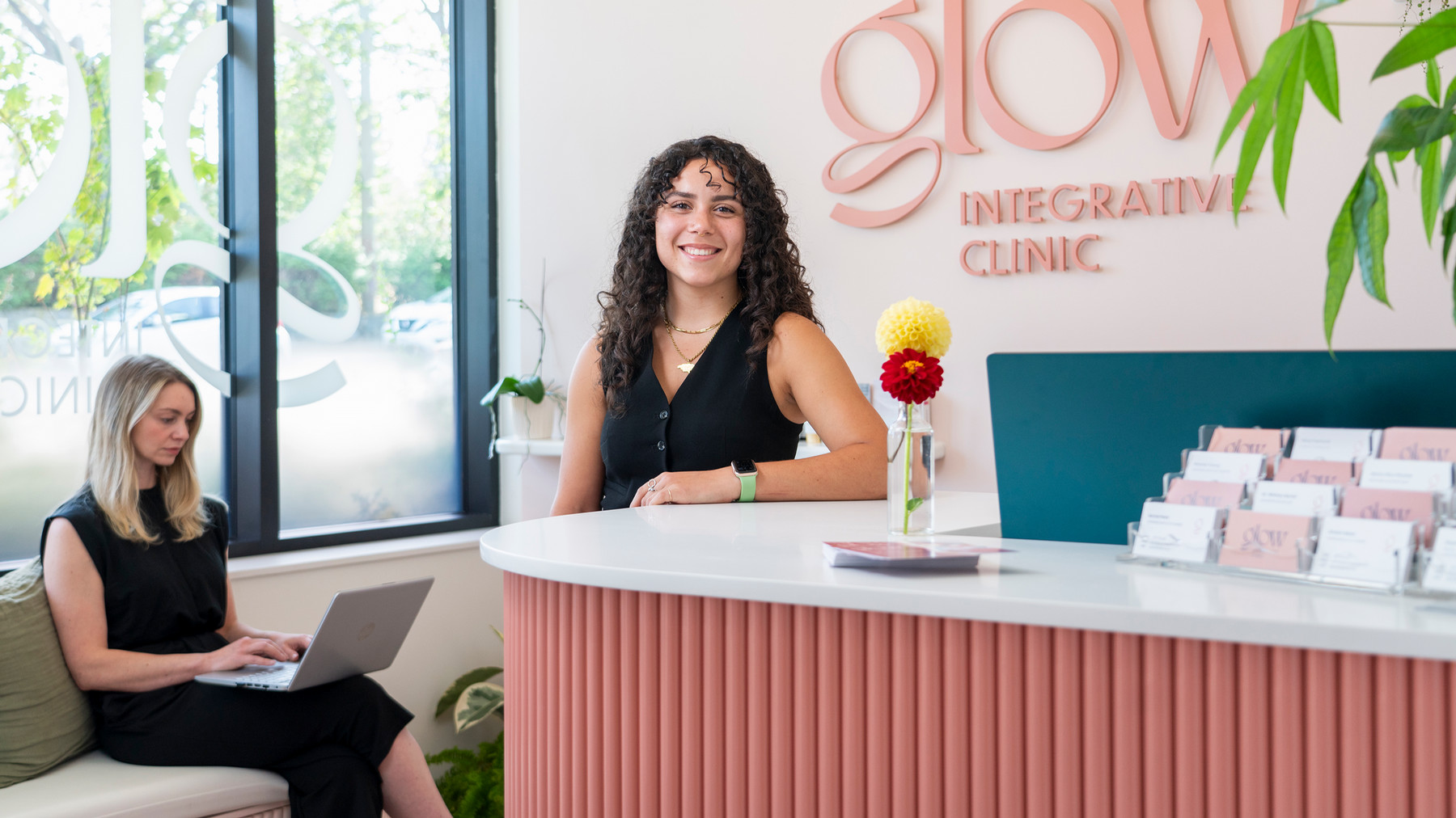 A student stands at the desk of a colourful and friendly health clinic.