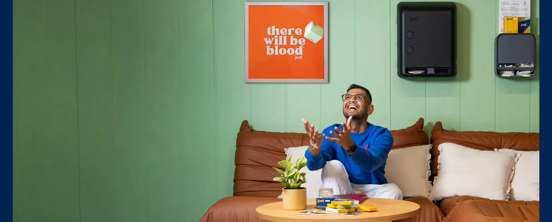 A person sits on a couch throwing a box into the air.
