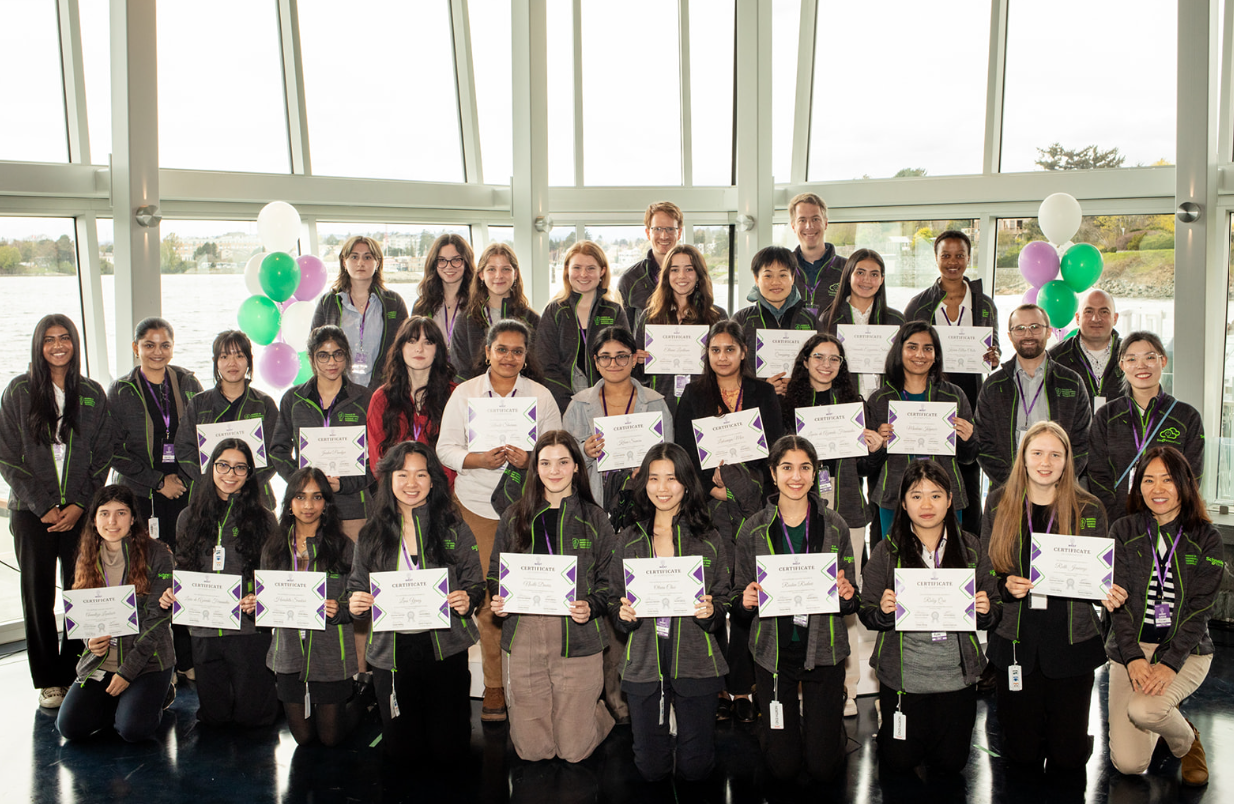 A group photo of The Women in Engineering, Science, and Technology student group holding certificates.