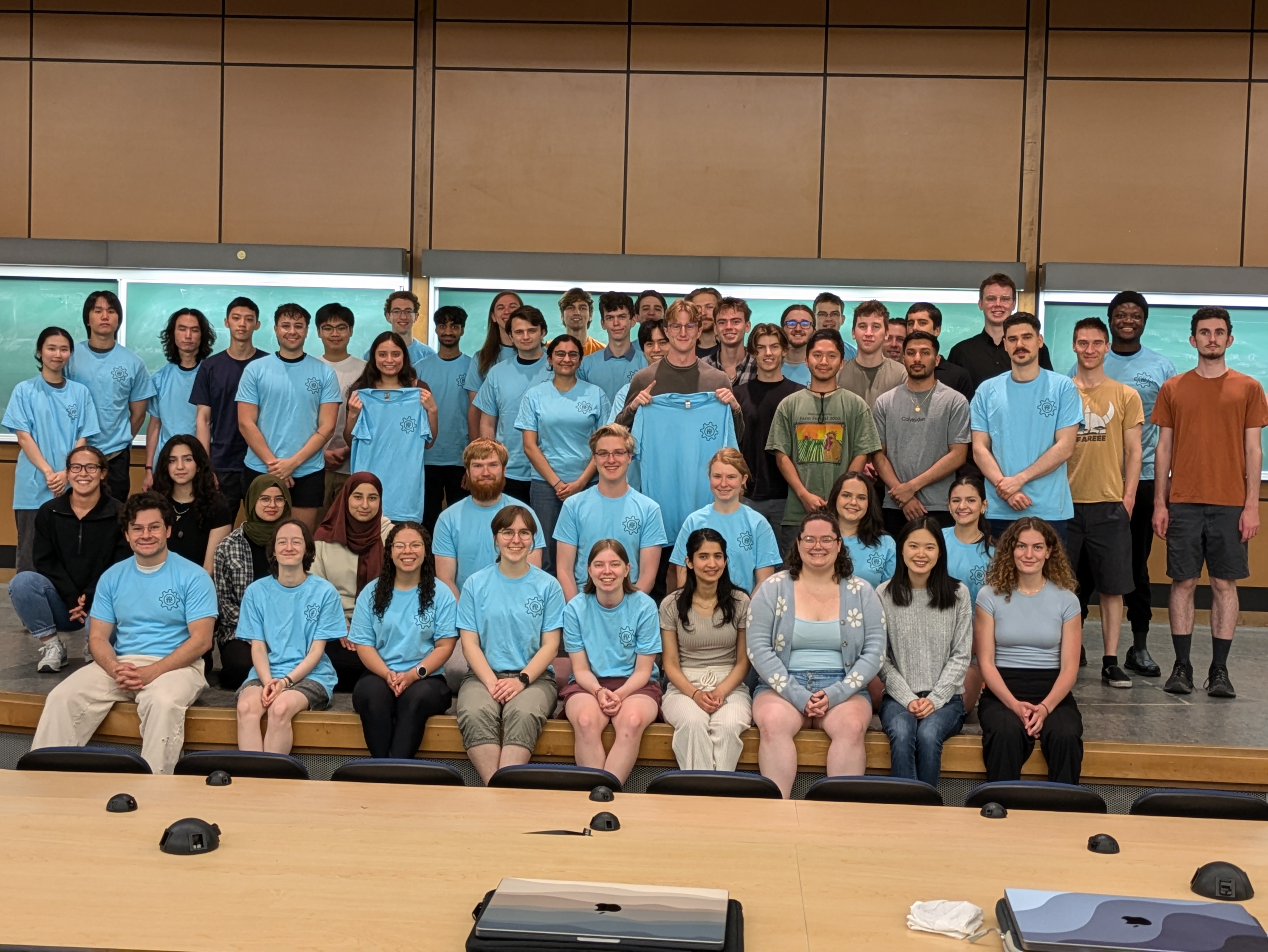 UVic ECS students sitting on the stage of a classroom.