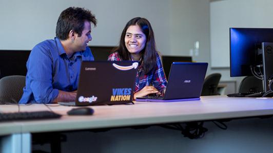 two students talking in computer lab