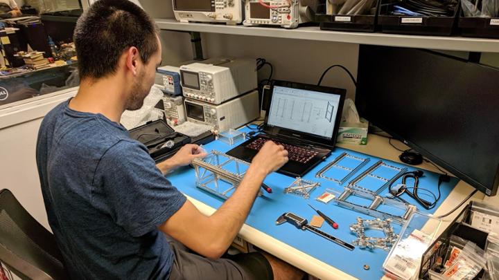 student working on satellite hardware