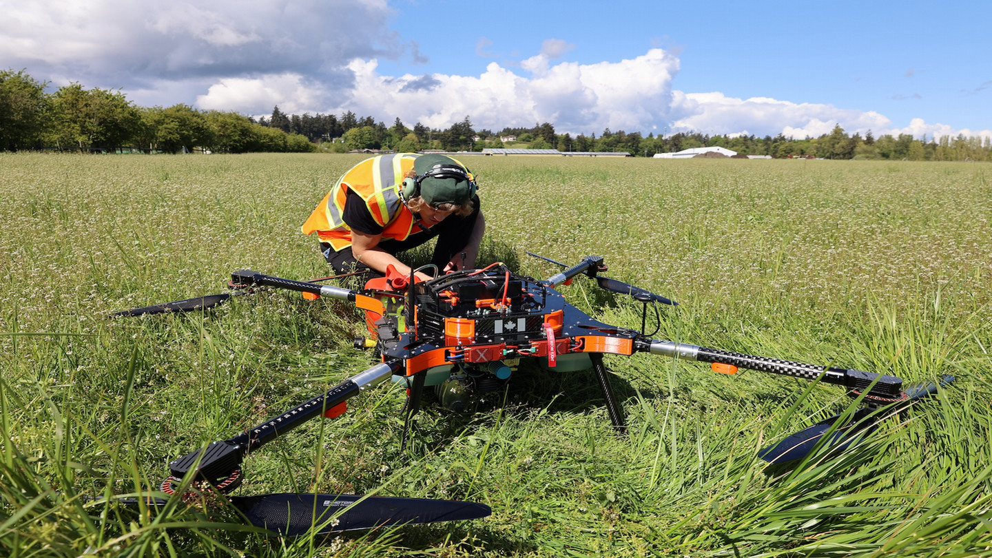 A man in a field with a large drone.